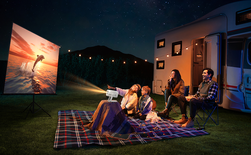Draagbare projector met een afbeelding van de zonsondergang op een buitenscherm. Mensen zitten's nachts op een deken naar een film te kijken buiten de camper, lichtslingers zichtbaar.