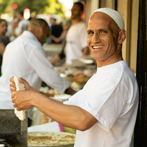 A photograph of a baker on the Rue du Faubourg du Temple shaping flatbreads during Ramadan. 