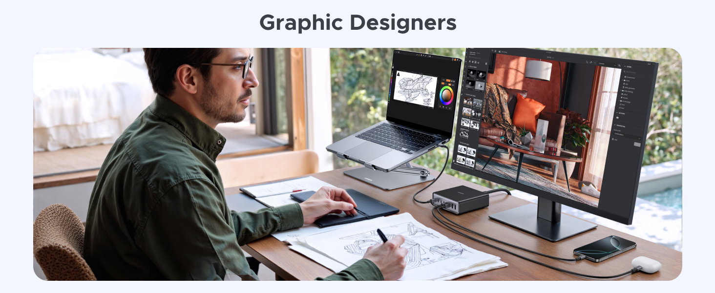 Computer setup with multiple monitors displaying graphic design software. A person works at the desk, using a graphics tablet for drawing.
