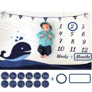 baby laying on whale milestone blanket