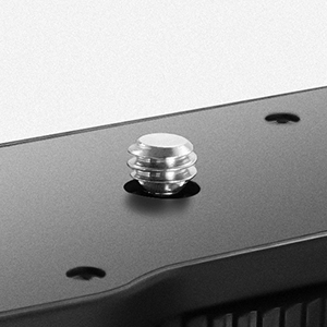 Close-up of a small, round, metallic knob or button on a dark surface, possibly part of an electronic device.