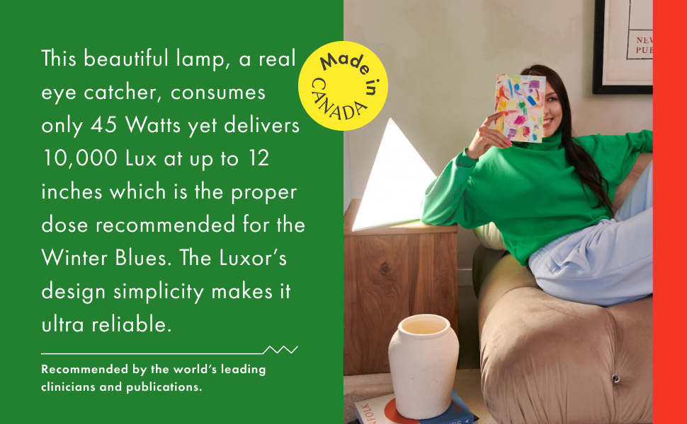 Woman sitting comfortably reading while using the Luxor bright light thearpy desk lamp.