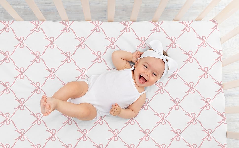 baby laying on crib sheet