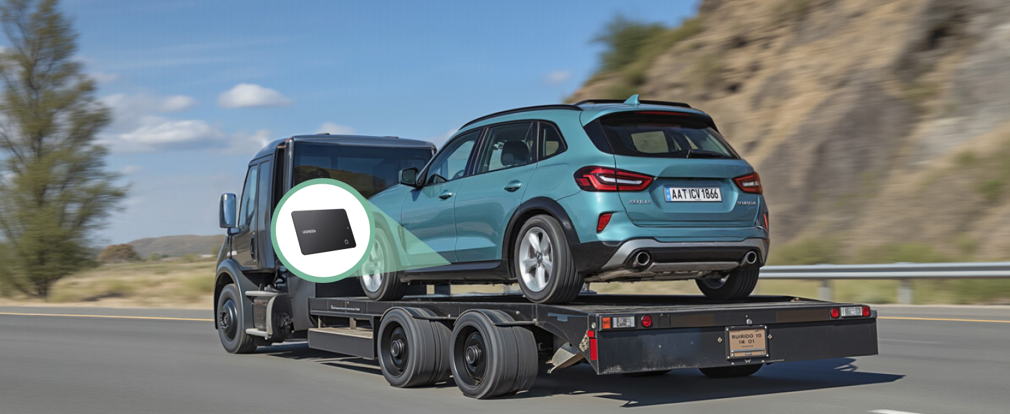Teal-colored SUV being transported on a car carrier trailer platform, photographed on a mountain road against rocky backdrop.