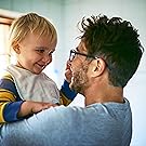 Father with a beaming smile cuddling his baby close, showcasing their deep bond