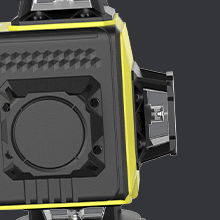 Gros plan d'un boîtier d'appareil photo ou d'appareil noir avec garniture jaune, montrant une monture d'objectif circulaire et un motif de grille de ventilation sur la surface