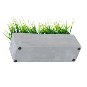 faux grass plant potted in cement planter