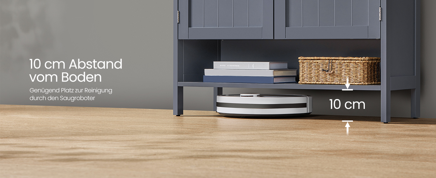 Sötétszürke tárolószekrény 10 cm magasságra a padlótól, könyvekkel és fonott kosárral. A szöveg a '10 cm távolság a padlótól' részre utal.