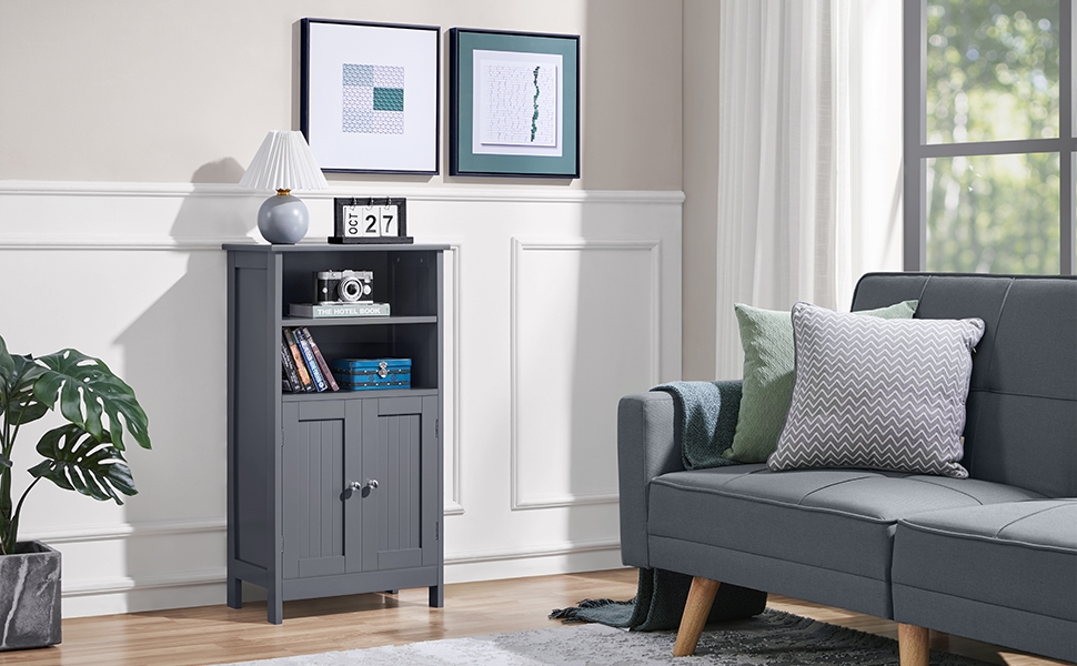 Gray living room featuring a tall, narrow bookshelf with closed cabinet, placed next to a gray sofa with decorative pillows and framed artwork above.