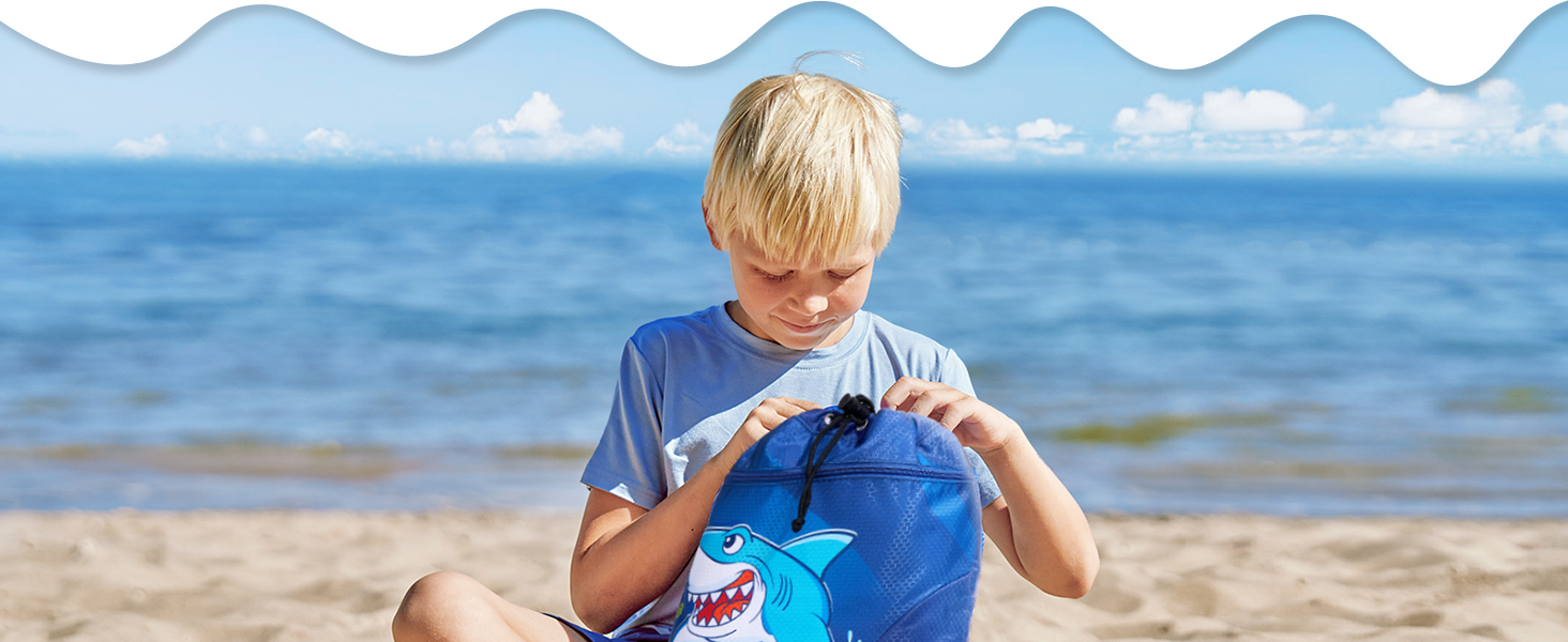 Une bouteille d'eau bleue sur une plage, tenue par une personne portant une chemise bleue. L'océan et la plage de sable sont visibles en arrière-plan.