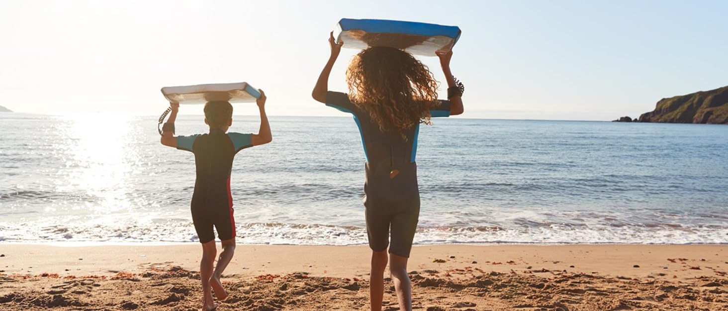 children playing on the beach with bodyboards 