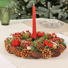 a pine cone and red candle on a table