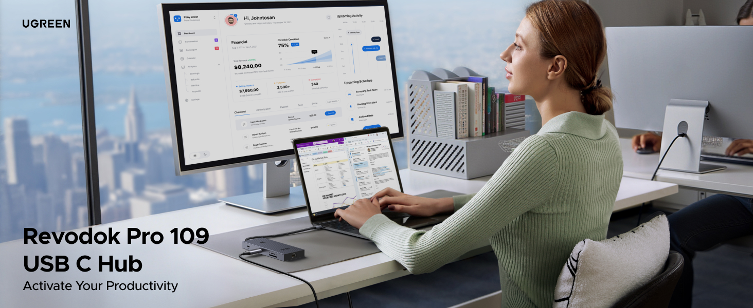Revodok Pro 109 USB C Hub shown in use with multiple monitors in an office setting. Person working at desk with cityscape view.