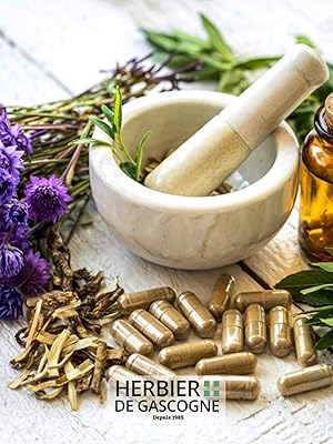 Présentoir de suppléments naturels ou de plantes médicinales présentant des herbes séchées, des capsules, des bouteilles d'huile essentielle, un mortier blanc et un pilon à fleurs violettes.