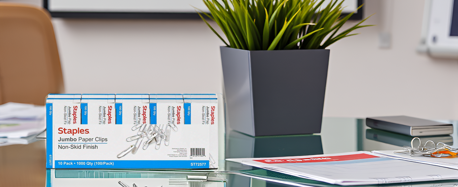 A desk with a neat stack of papers held together by the product.