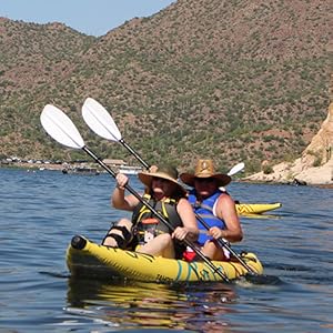 A husband and wife paddling the Buoy Watersports Tandem Tahoe Kayak on a lake