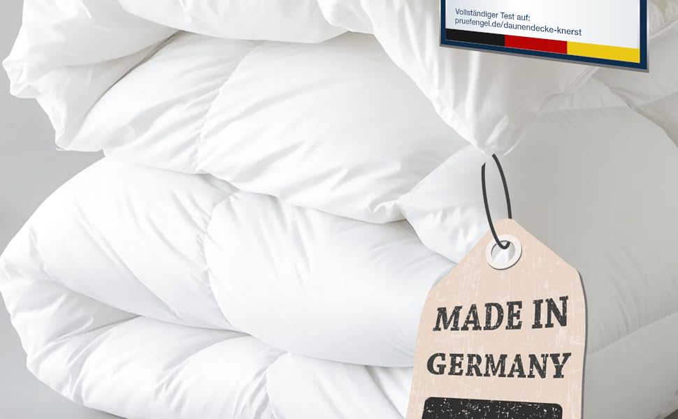 White bedding set including pillows and duvet. Attached tag reads 'MADE IN GERMANY', indicating product origin.