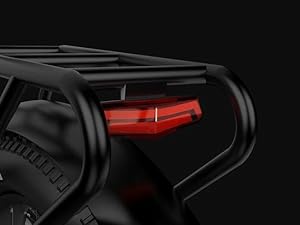 Close-up view of a black bike rack or carrier system with red accent components visible against dark background.