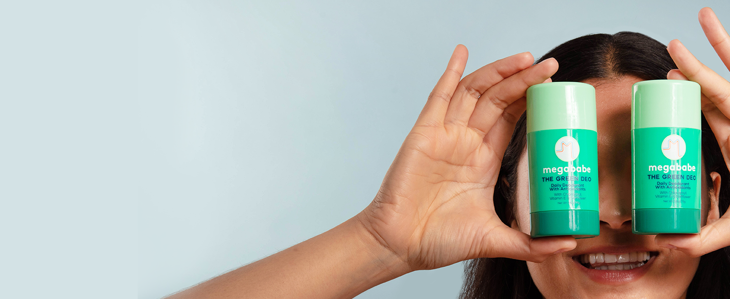 Two megababe green deos being held up in front of someones face.