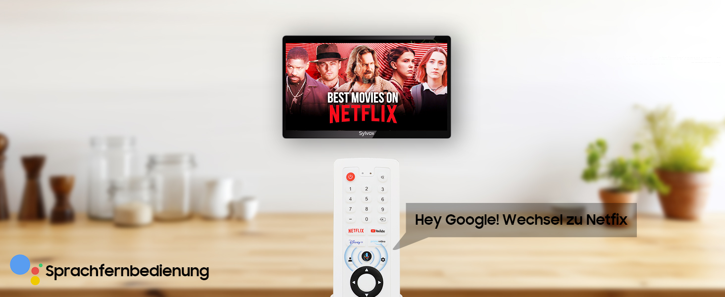 An der Wand montierter Flachbildfernseher, auf dem ein rotes Programm angezeigt wird. Unten befindet sich ein weißes Gerät mit Tasten und einem kleinen Bildschirm auf einer Oberfläche