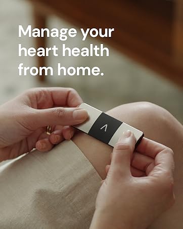 Hands holding a small, square device with a screen. Text overlay reads 'Manage your heart health from home.' The device appears to be a portable health monitor.