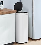 Tall cylindrical white kitchen trash can with black lid, showing touchless sensor opening mechanism, placed against kitchen cabinetry.