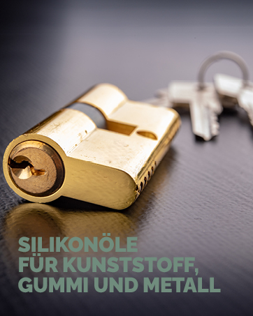 Gold-colored metal padlock with keys on a dark surface. Cylindrical lock body with visible keyhole. Text in German visible at bottom of image.