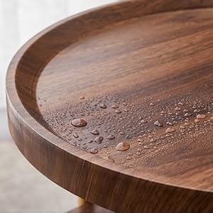 Circular wooden table surface with protective coating features, showing water droplets demonstrating water-resistant properties.