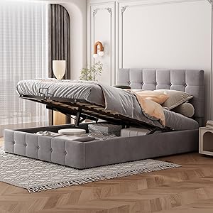 Grey upholstered storage bed with tufted headboard shown with lifted hydraulic base, revealing storage space beneath. Features modern design with grey bedding.
