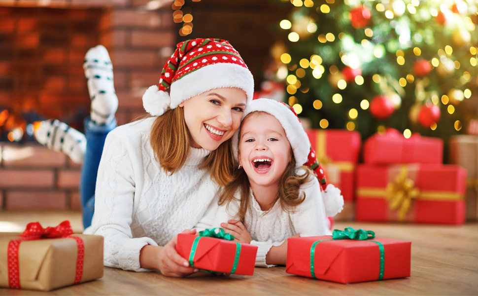 Holiday scene with wrapped presents and Christmas tree in background, featuring red and white Santa hats.