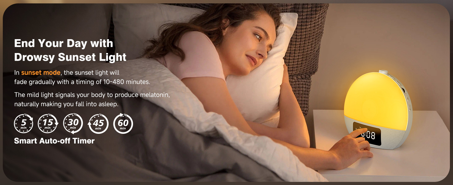 Yellow spherical alarm clock with sunset light simulation and smart features. Display shows time and icons for various functions. Person sleeping in background.