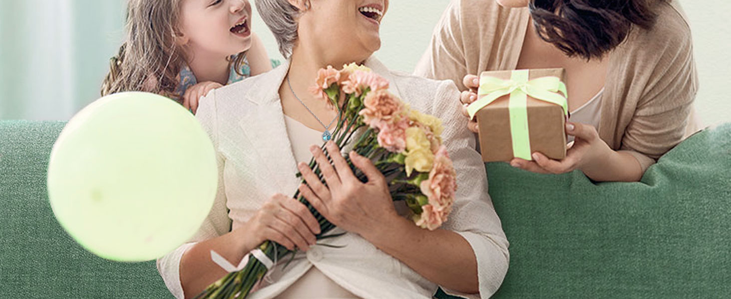 Trois personnes sur un canapé vert, l'une tenant un bouquet de fleurs, l'autre tenant un coffret cadeau avec un ruban. Vue partielle d'une superposition circulaire jaune pâle