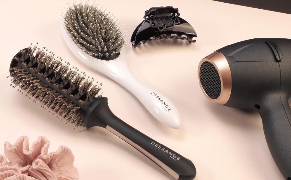 Dessange Paris comprenant un sèche-cheveux, diverses brosses, des pinces à cheveux et un élastique à cheveux sur fond beige