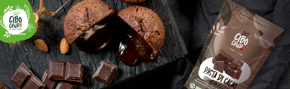 Pezzi di cioccolato fondente e biscotti al cioccolato spezzati disposti su una superficie nera con il prodotto confezionato visibile nell'angolo