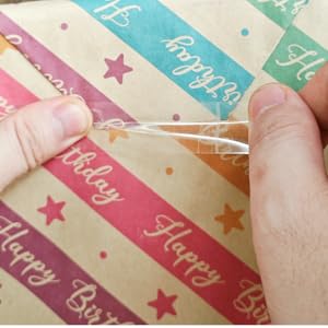 Gift wrapping paper cutter with tape dispenser