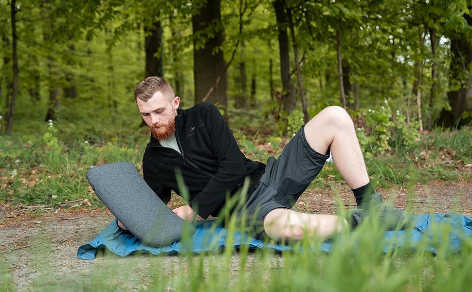 Homme sur un matelas de camping avec un coussin de voyage Woodilla