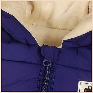 Close-up of a purple puffer jacket's collar and zipper. The jacket has a quilted texture and a white fleece lining visible at the neckline.