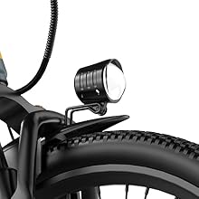 Close-up black and white image of bicycle headlight mounted on handlebars, showing curved mounting bracket and circular light fixture.
