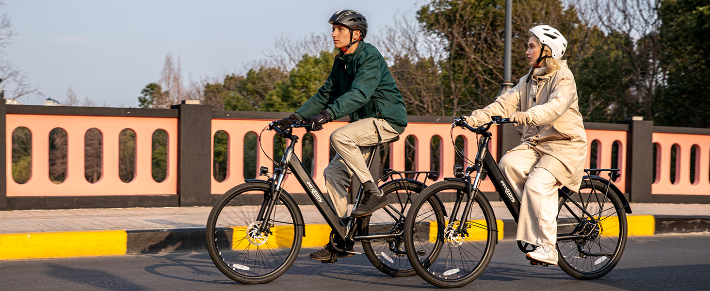 Bilderserie, die Menschen zeigt, die auf einem Weg neben Gebäuden mit kunstvoller Architektur radeln. Radfahrer fahren auf einer malerischen Route, auf der Bäume und architektonische Details sichtbar sind.
