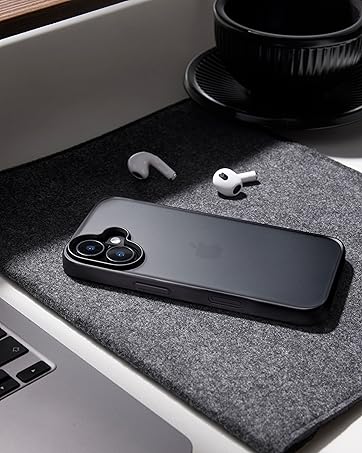 Black smartphone on grey desk mat with wireless earbuds and partial view of laptop. Sleek design showcases modern tech accessories in minimalist setting.