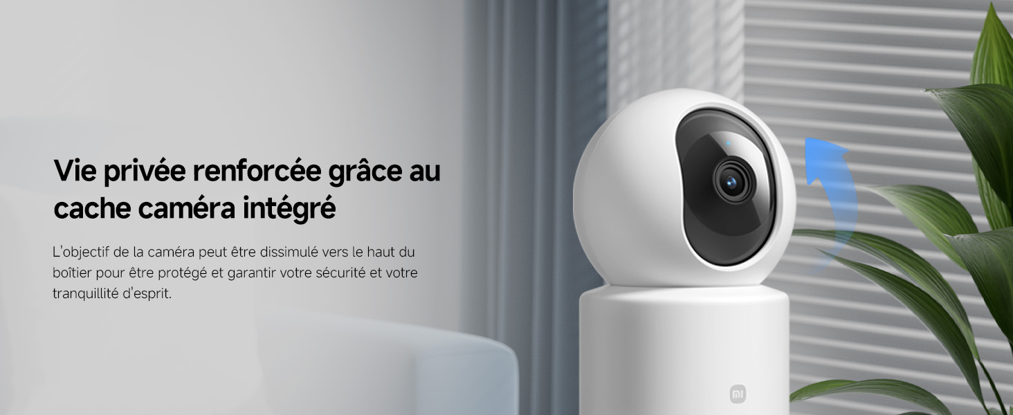 Caméra de sécurité blanche ou dispositif de surveillance monté sur le mur intérieur près d'une plante verte, avec affichage de l'interface indiquant les paramètres de la caméra.