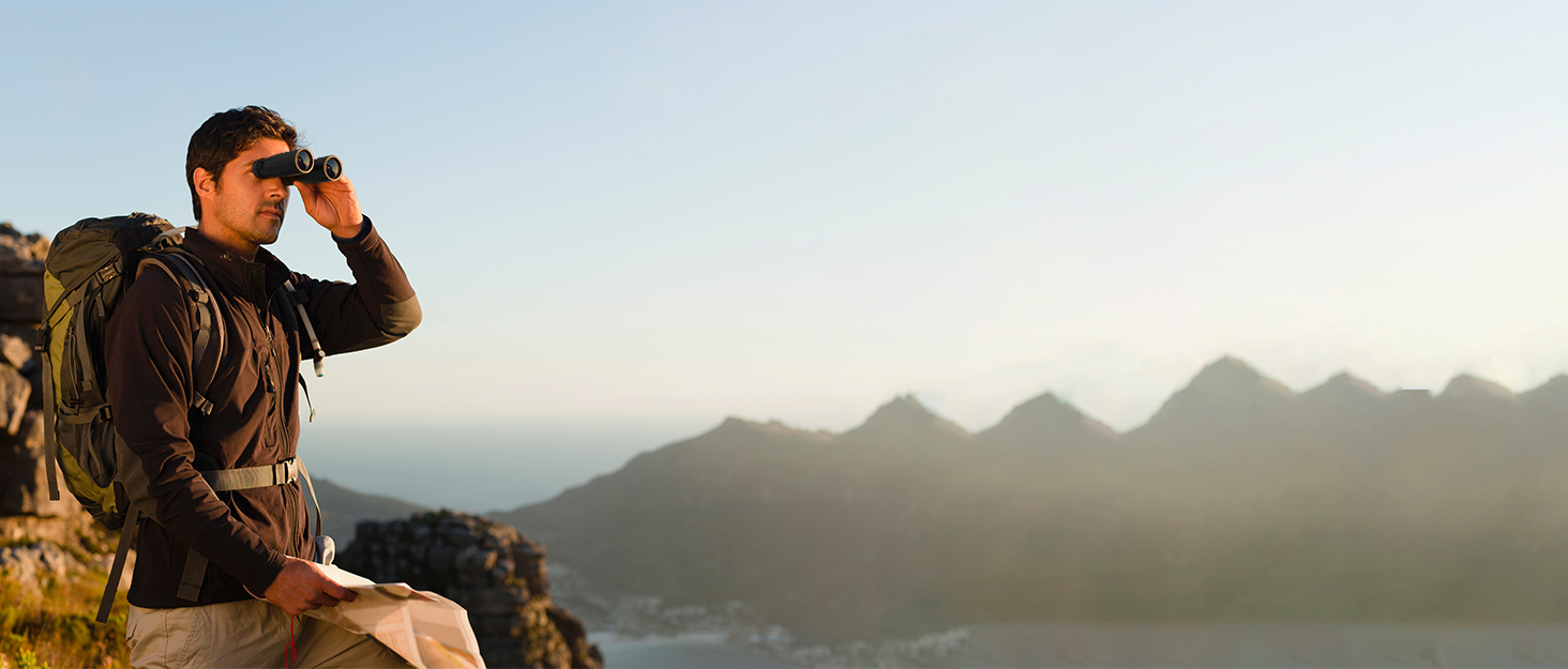 una mujer tomando una foto del océano desde una montaña