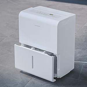 a close up of a white dehumidifier sitting on a gray tile floor with front water tank opened
