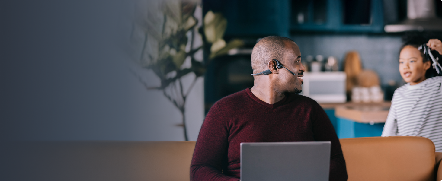 ein Mann, der ein Headset auf seinem Laptop trägt