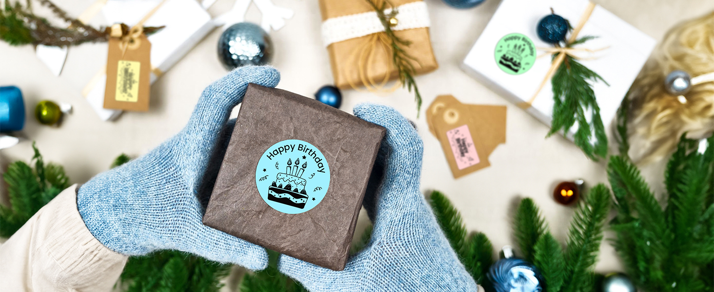 Blue mittened hands holding brown leather wallet against holiday backdrop with ornaments, gift tags, and evergreen branches.
