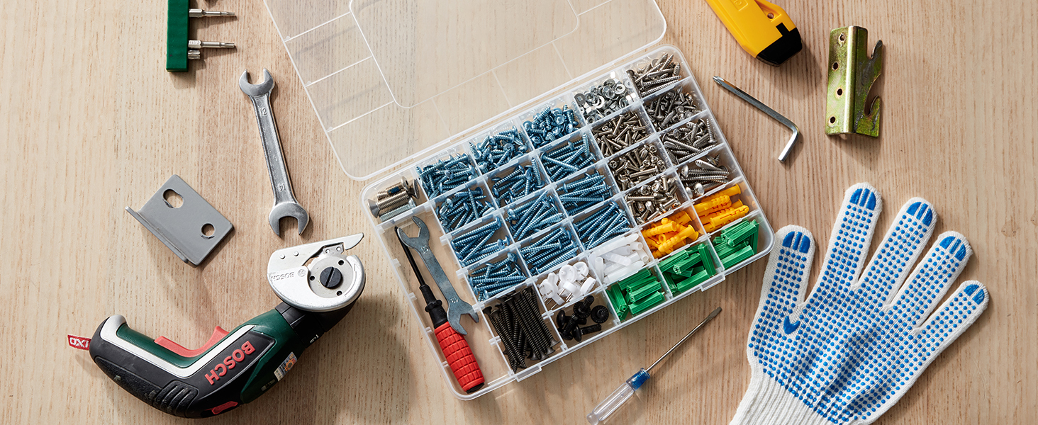 Sortiment an Handwerkzeugen und Hardware auf Holzoberfläche. Inklusive Schraubenzieher, Zange, Schraubenschlüssel, Schrauben in der Organizer-Box, Maßband und Arbeitshandschuhe