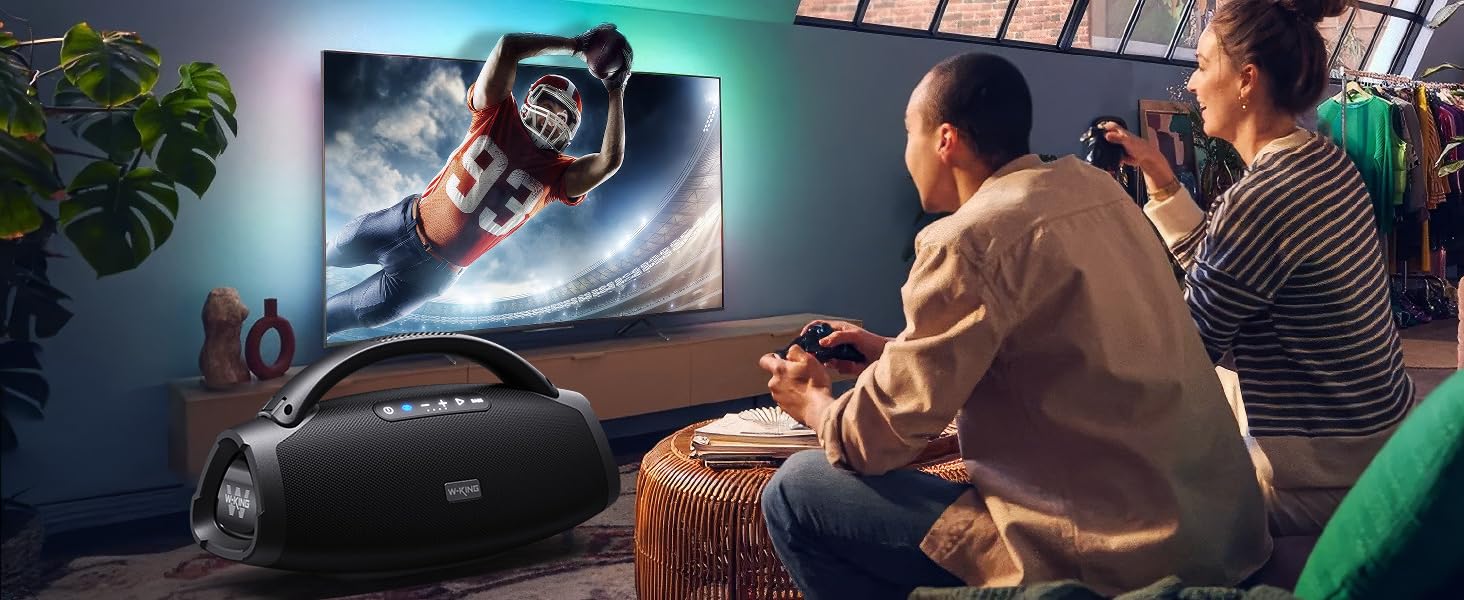 a man sitting in a living room playing a game on a tv.