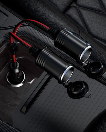 Two black cylindrical electronic devices with red wiring and mounting clips, shown against a dark textured surface.