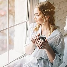 A person sipping coffee with mushroom extract blend powder and looking out the window