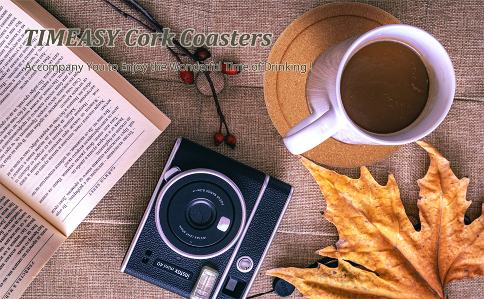 A cup is placed on the coaster along with the book and camera on the table.